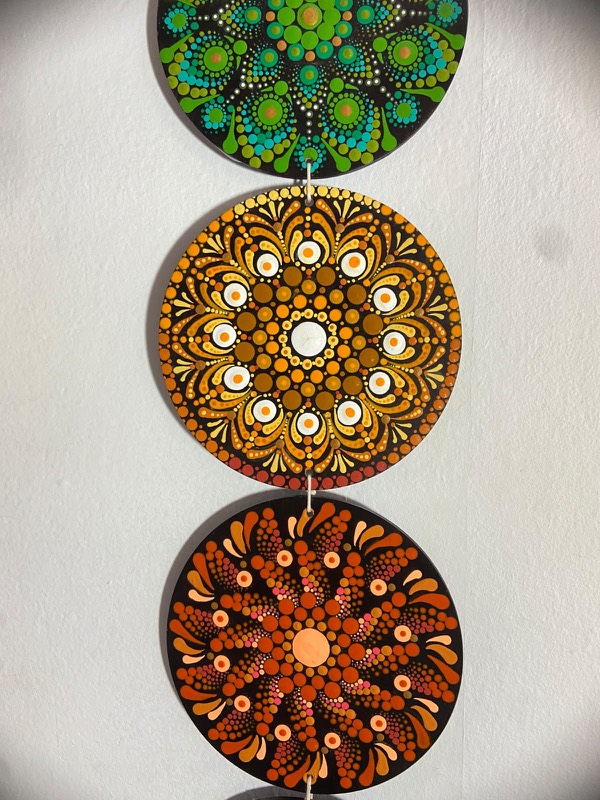 Detalhe de mandalas verde e âmbar em fio
