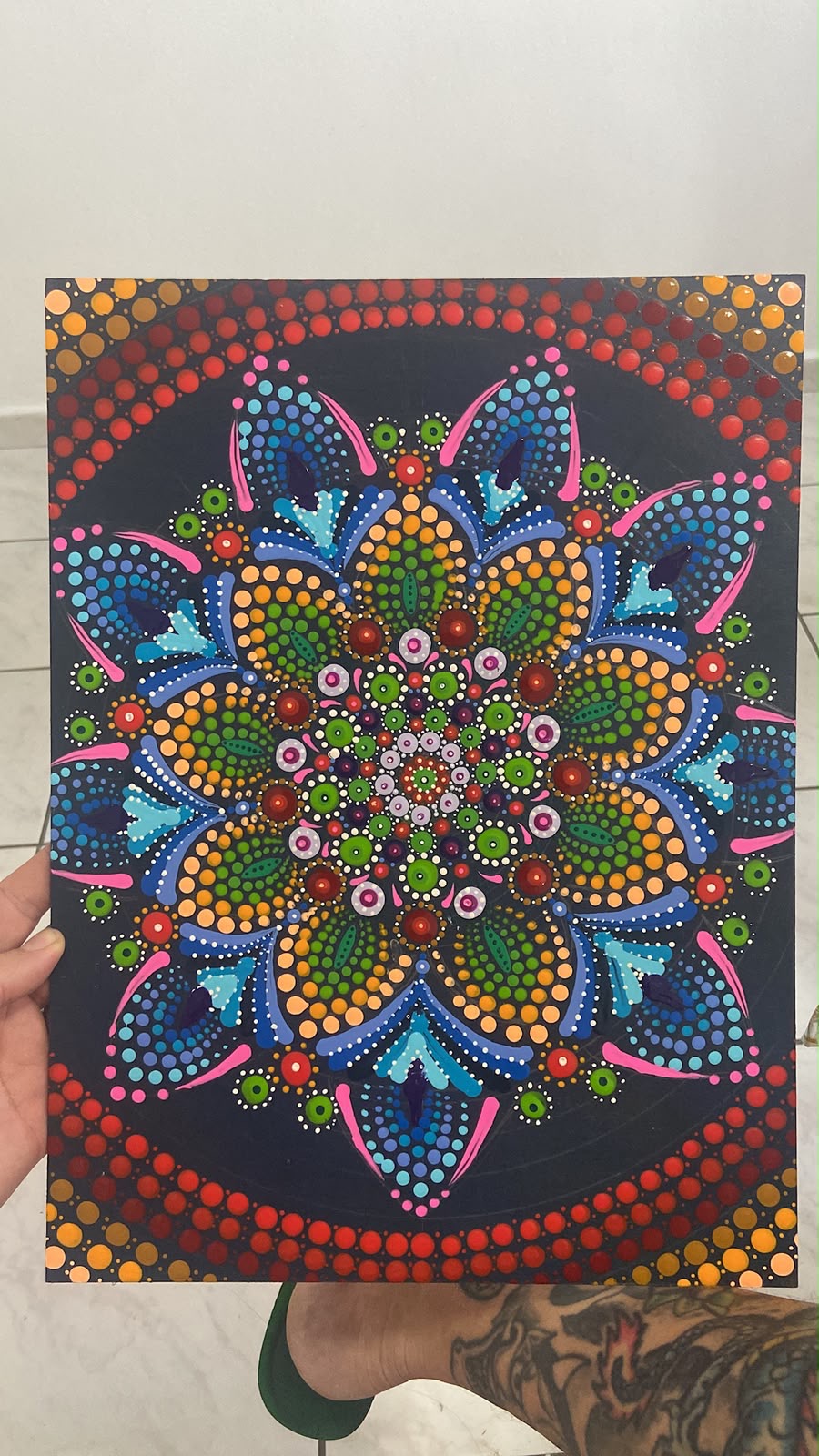 Mandala em dot art segurada pelas mãos de quem a criou